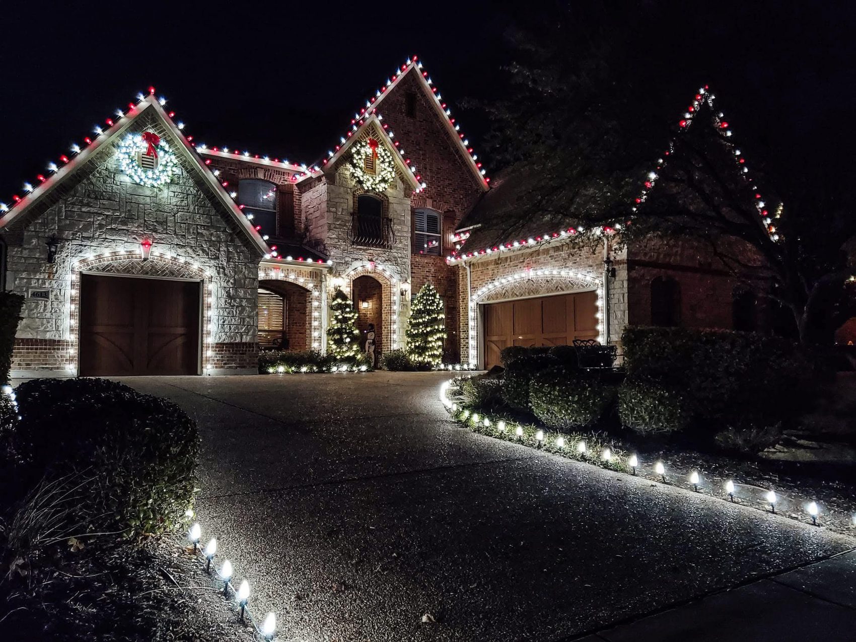 Central AL Lighting Christmas light installation on a brick and stone home