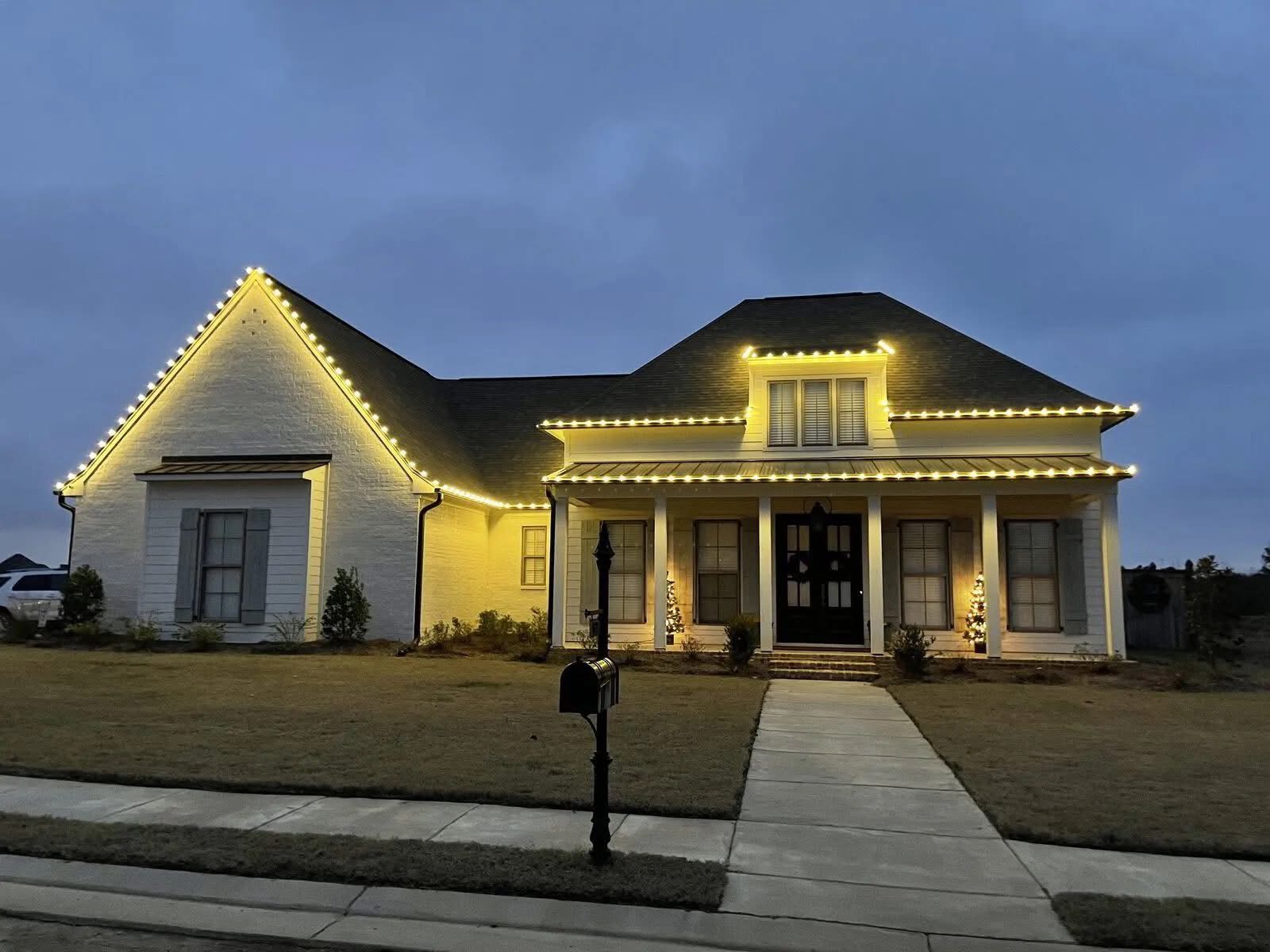 Central AL Lighting roofline and porch installation on a home at dusk